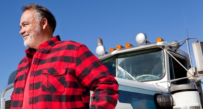 Construction worker standing in front of his construction vehicle
