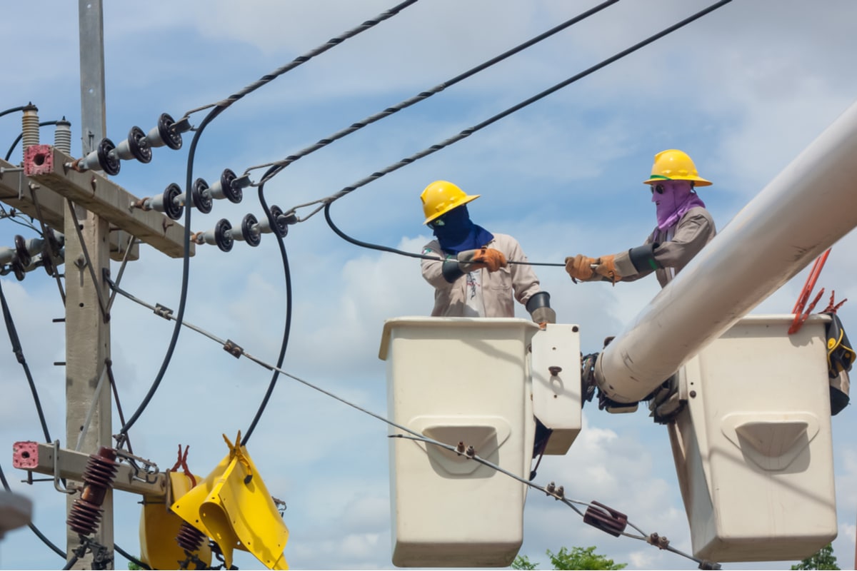 Utility workers in bucket truck fixing power lines